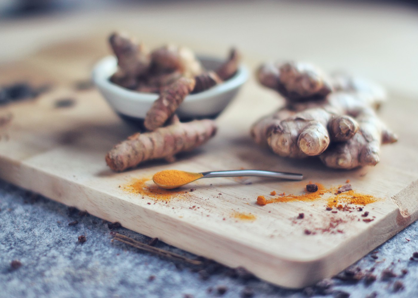 Fresh turmeric and ginger root on a chopping board