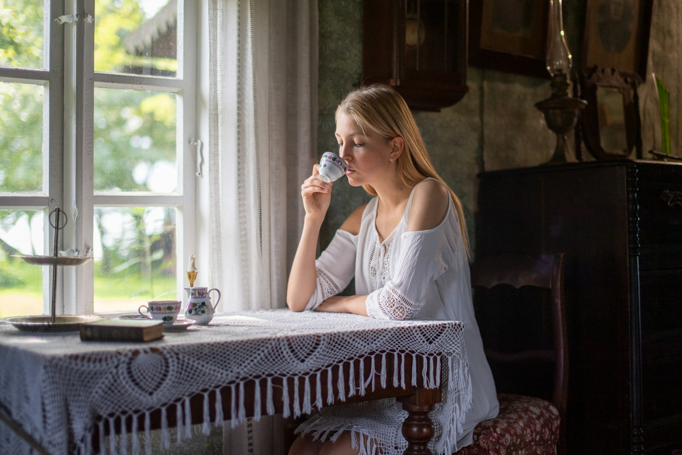 Woman enjoying a cup of tea by a window